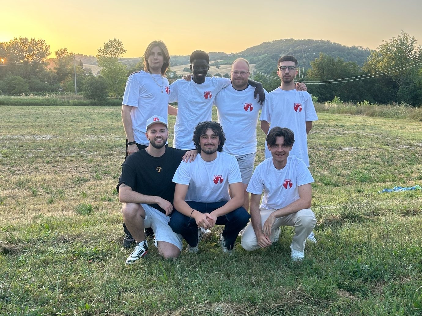 I volontari con le magliette Distesi sul prato del campo al tramonto